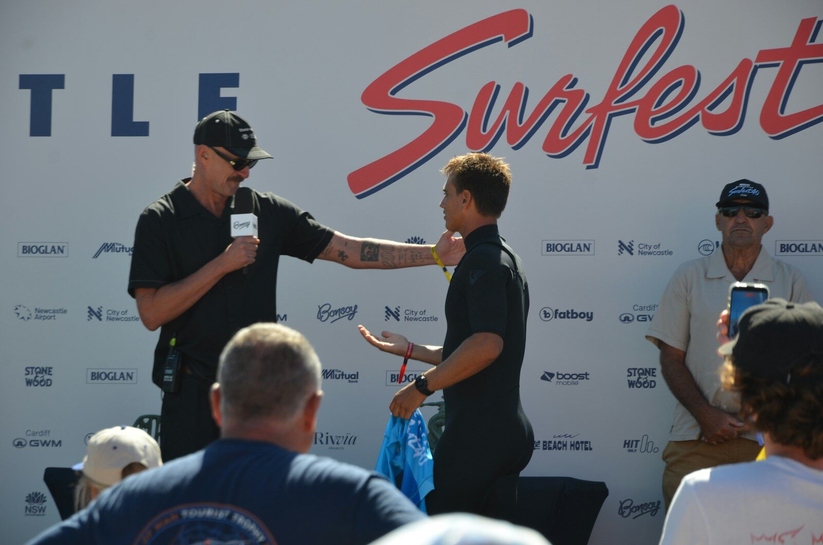 Two men interacting at a surf fest event