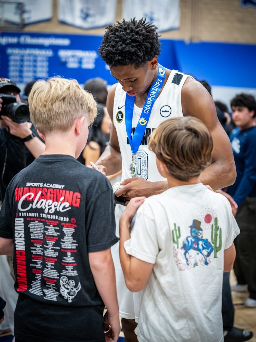 Basketball player signs autographs for young fans