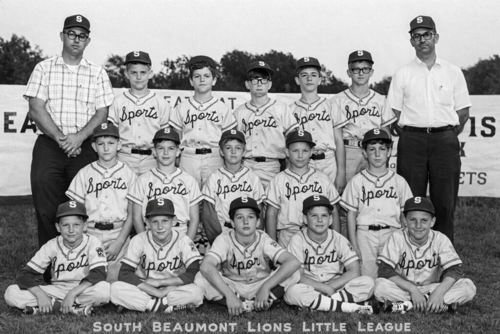 South Beaumont Lions Little League — 1970. Twelve young players and two coaches stand proudly in their uniforms marked “Sports,” representing the spirit of community and youth baseball in Beaumont, Texas. John is second from the left on the bottom row (First year of three in the Majors of the Lions Little League)